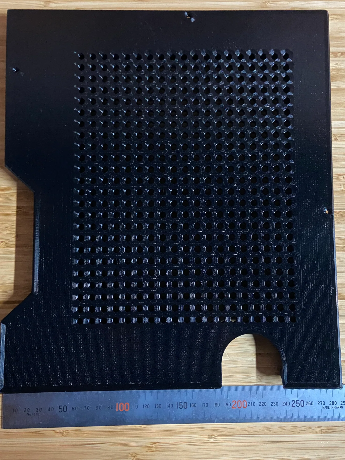 Black 3D-printed HVAC cover panel with a hexagonal ventilation pattern beside a 300 mm ruler
