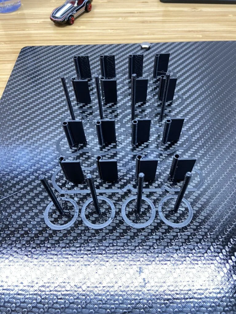 Batch of small printed hardware components on a print bed