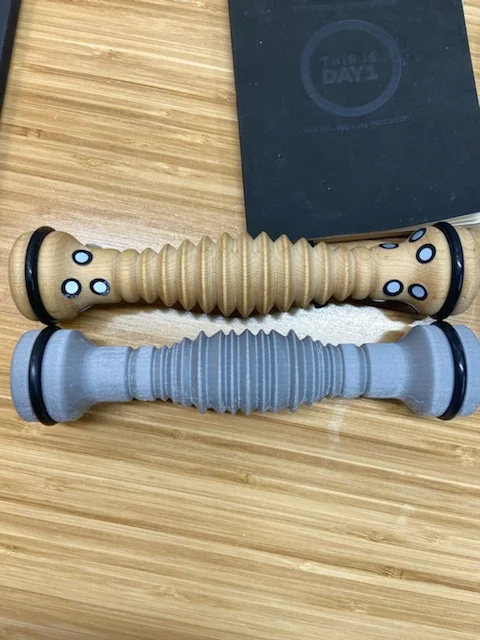 Worn wooden roller above its 3D-printed replacement